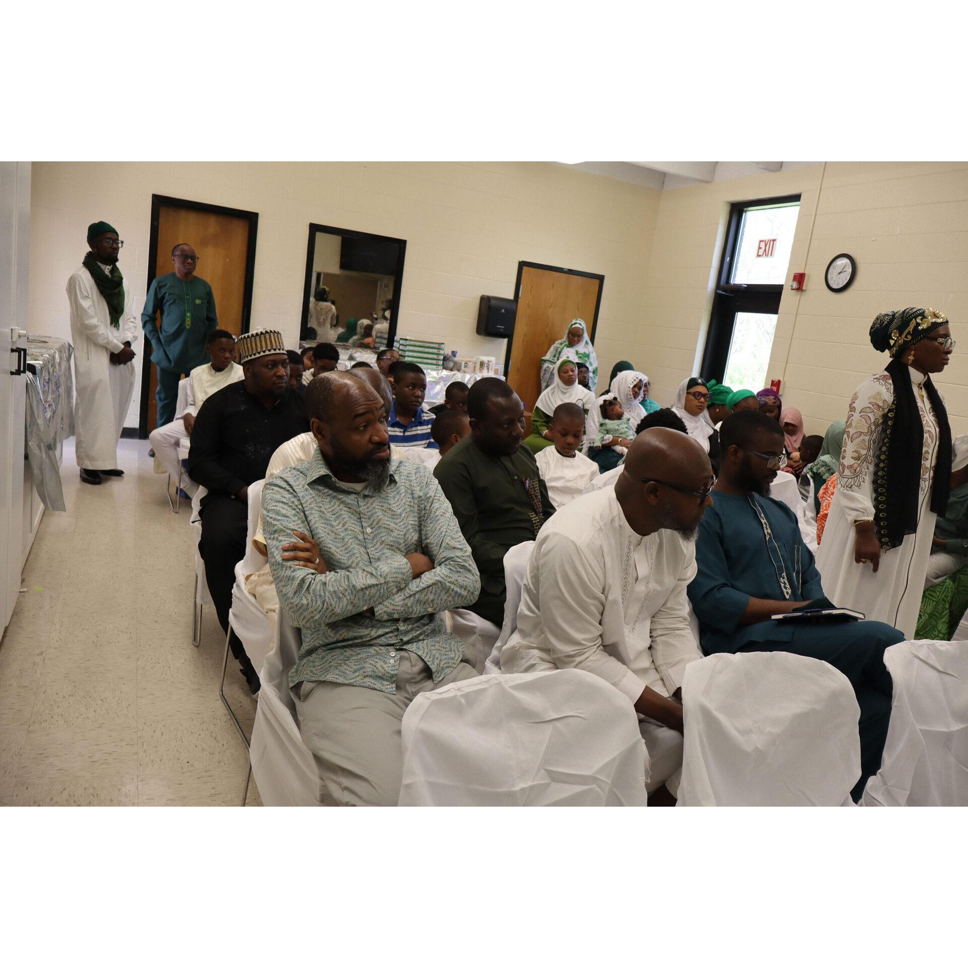 Community members seated in a bright prayer hall